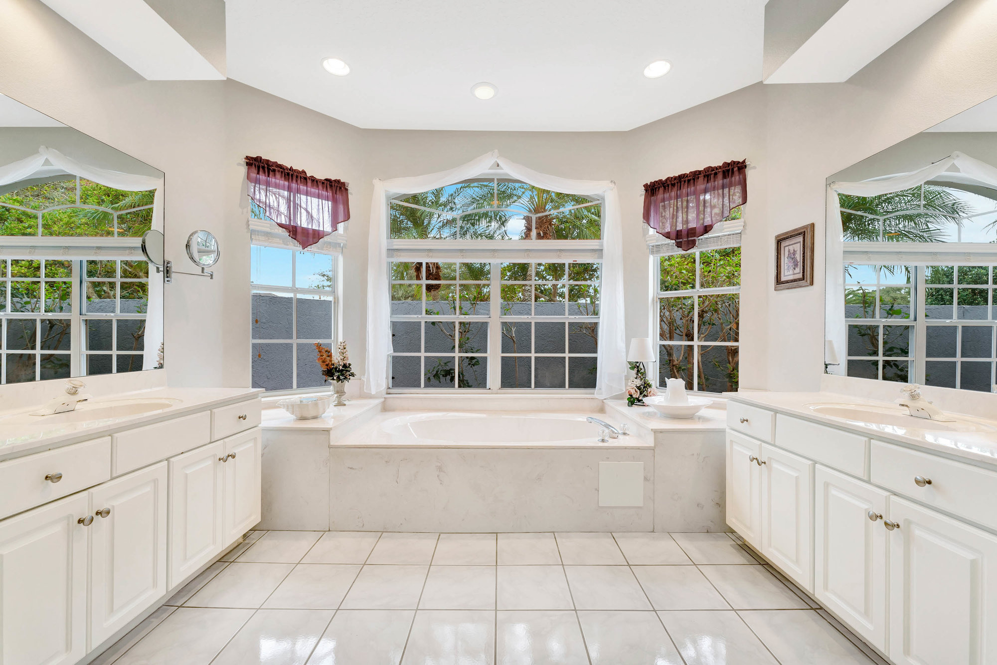 primary bathroom with white cabinets and tile